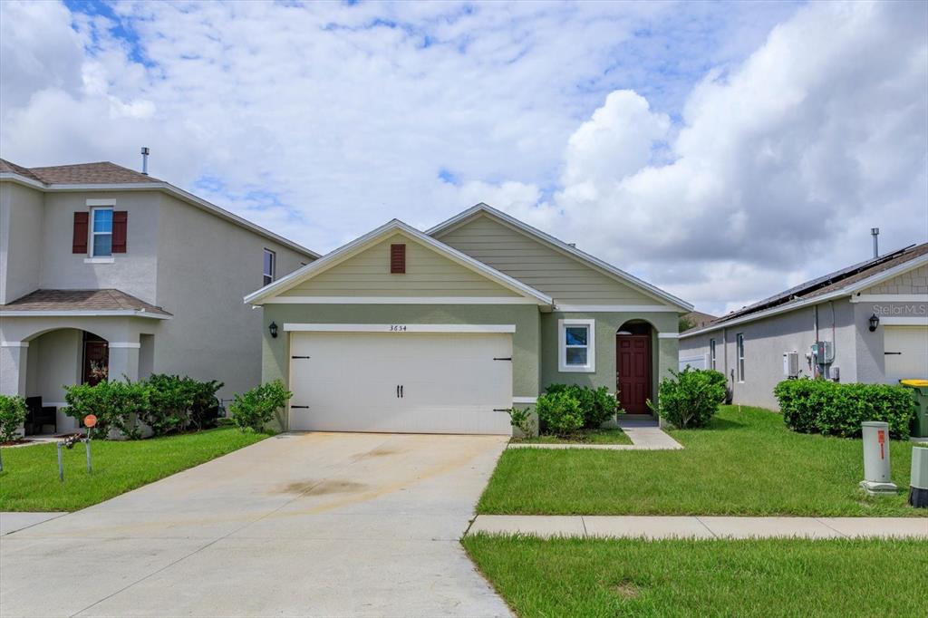 a front view of a house with a yard and garage