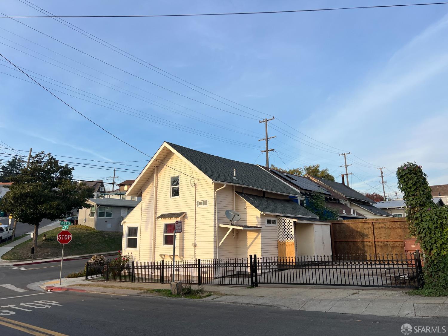 a view of a big house with wooden fence