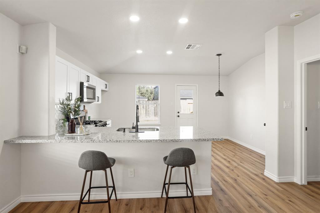 a kitchen with a dining table chairs and sink