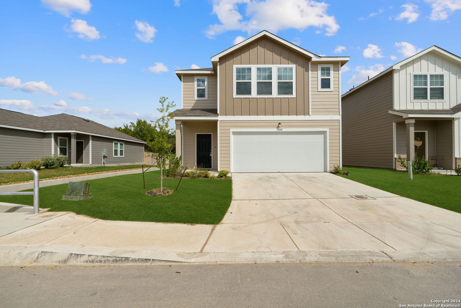 a front view of a house with a yard and garage