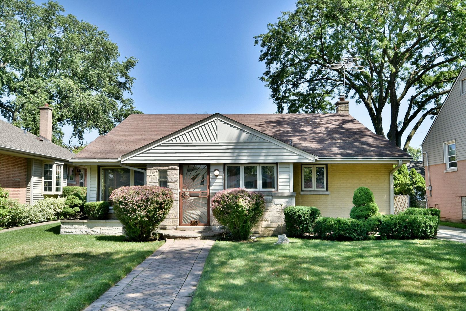 a front view of a house with a garden and plants