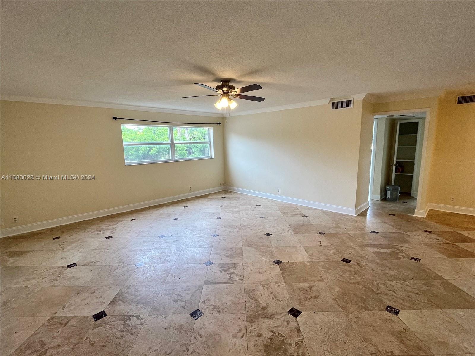 en empty room with windows and ceiling fan