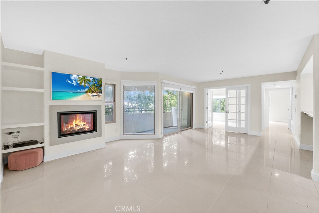 a view of an empty room with a fireplace and a window