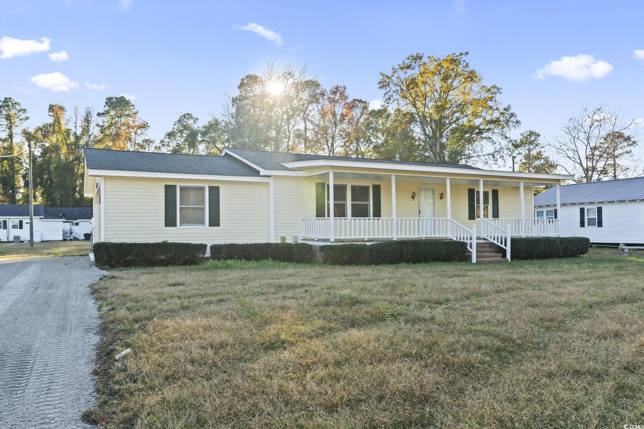 View of front of house with a porch and a front ya