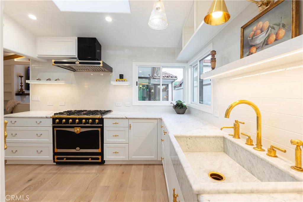 a kitchen with stainless steel appliances a stove a sink and a microwave