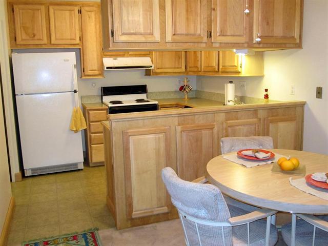 a kitchen with stainless steel appliances granite countertop a sink a refrigerator and a stove