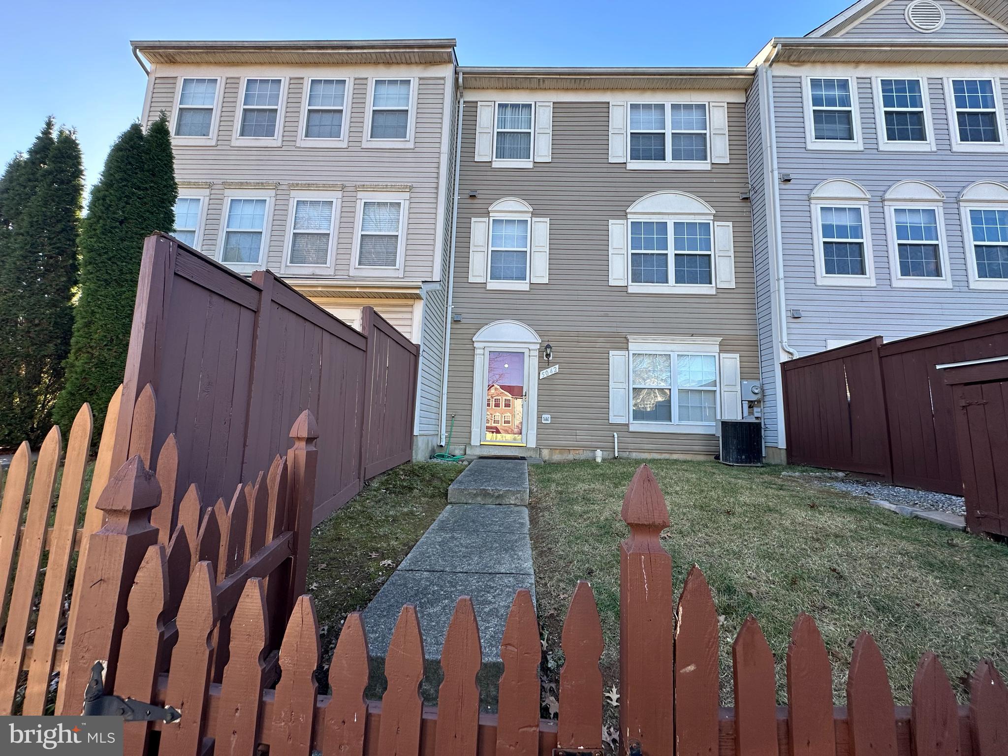 a view of a house with wooden fence