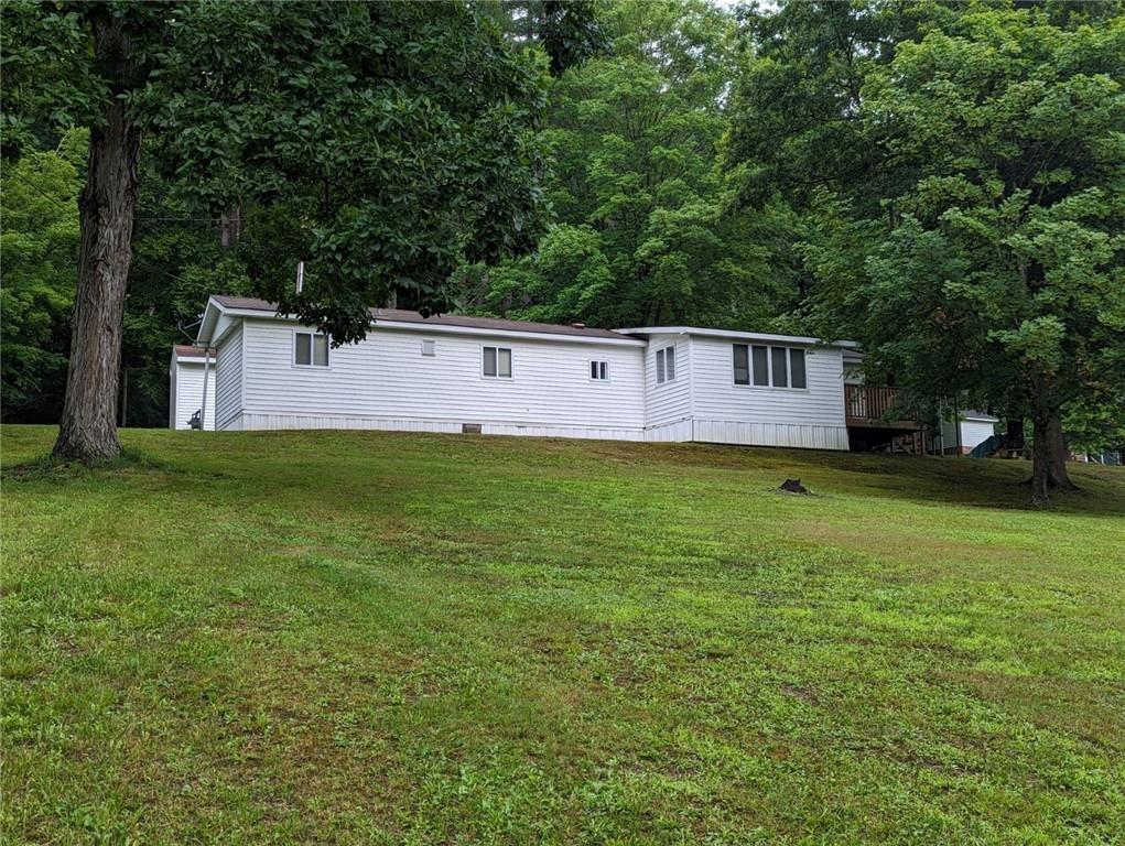 a view of a house with a backyard and a tree