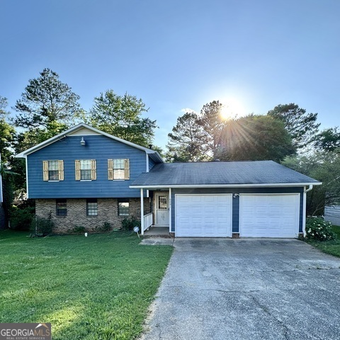 a front view of a house with a garden and plants