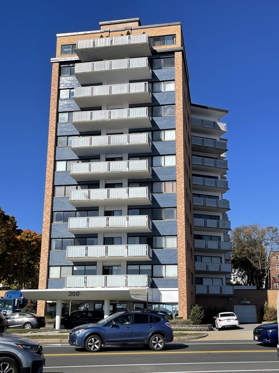 a front view of a building with streets and trees