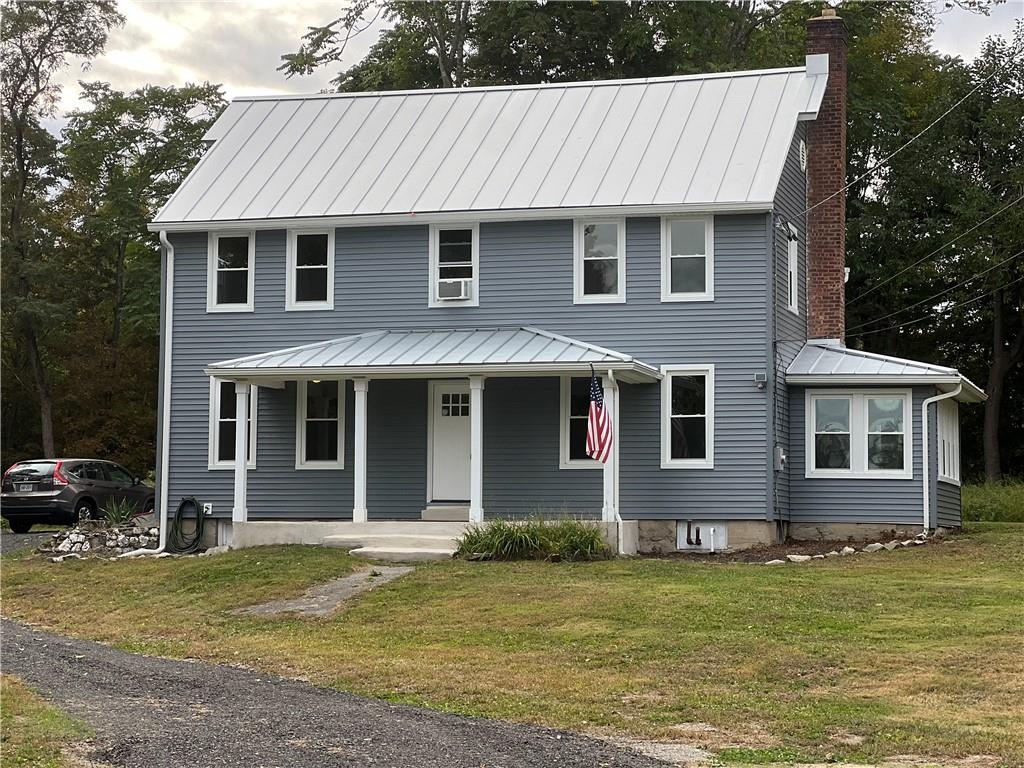 View of front of house featuring covered porch and a front yard