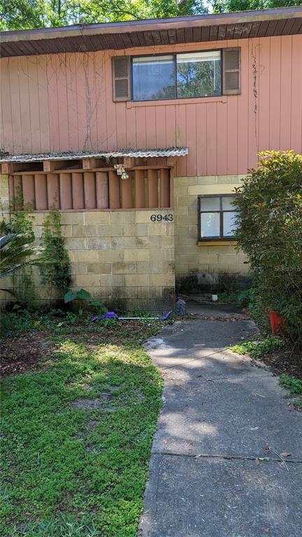 a view of a backyard with plants and large tree