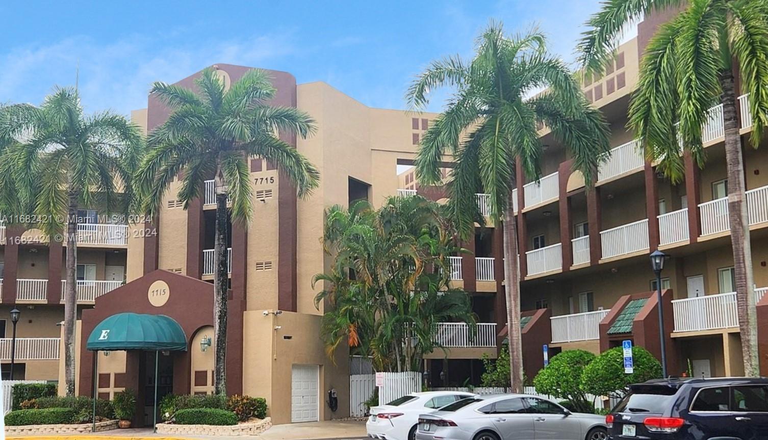 a front view of a building with palm trees