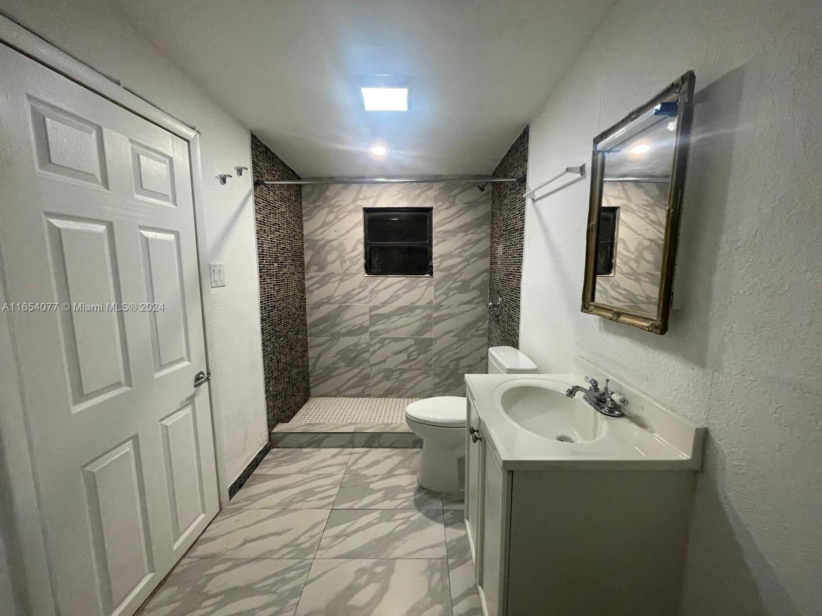 a bathroom with a sink a toilet and mirror