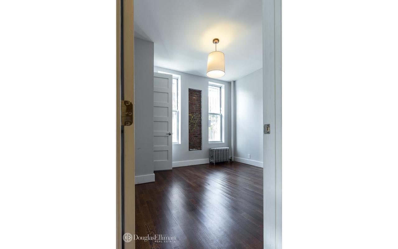 a view of a hallway with wooden floor