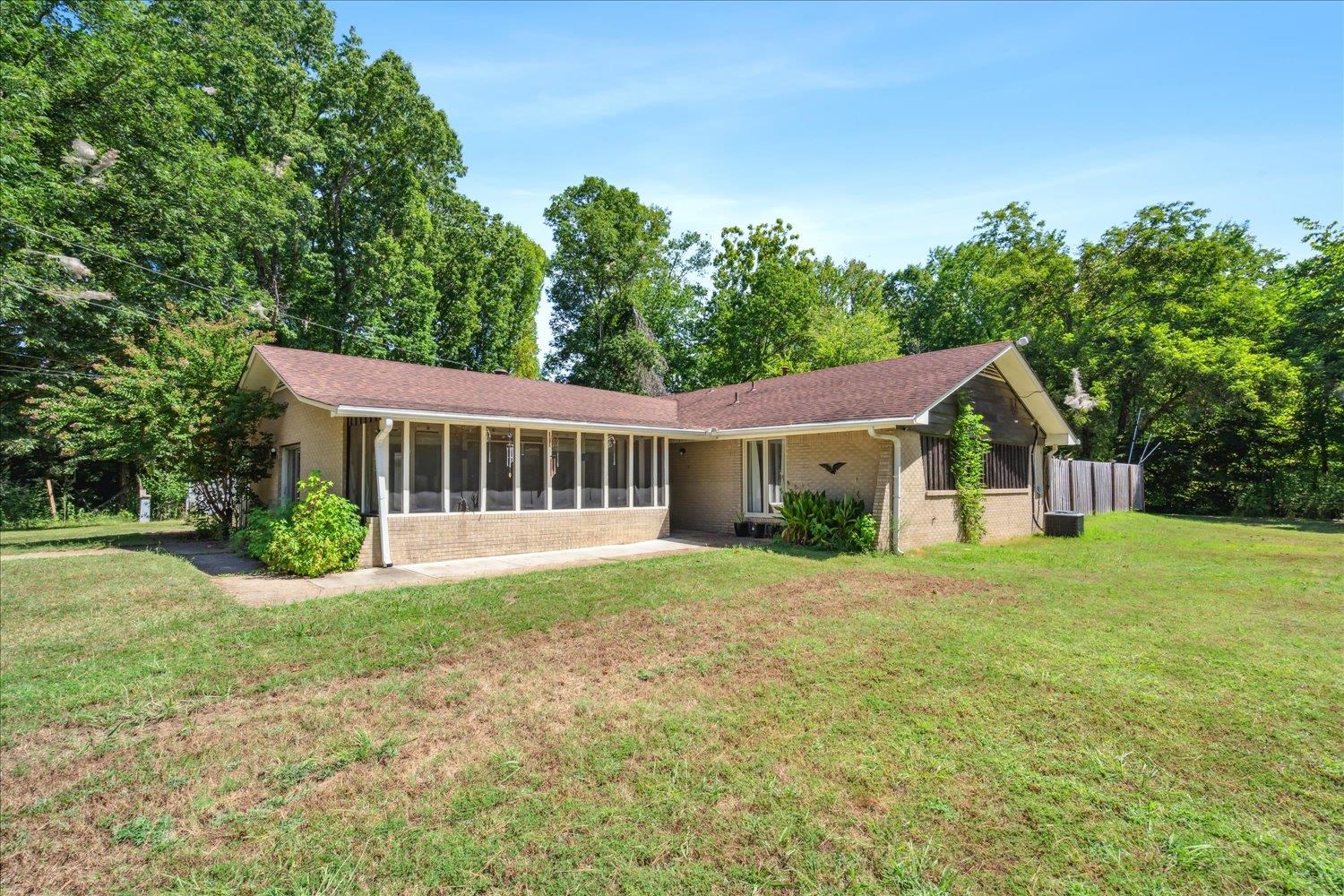 View of front facade featuring a sunroom and a front yard