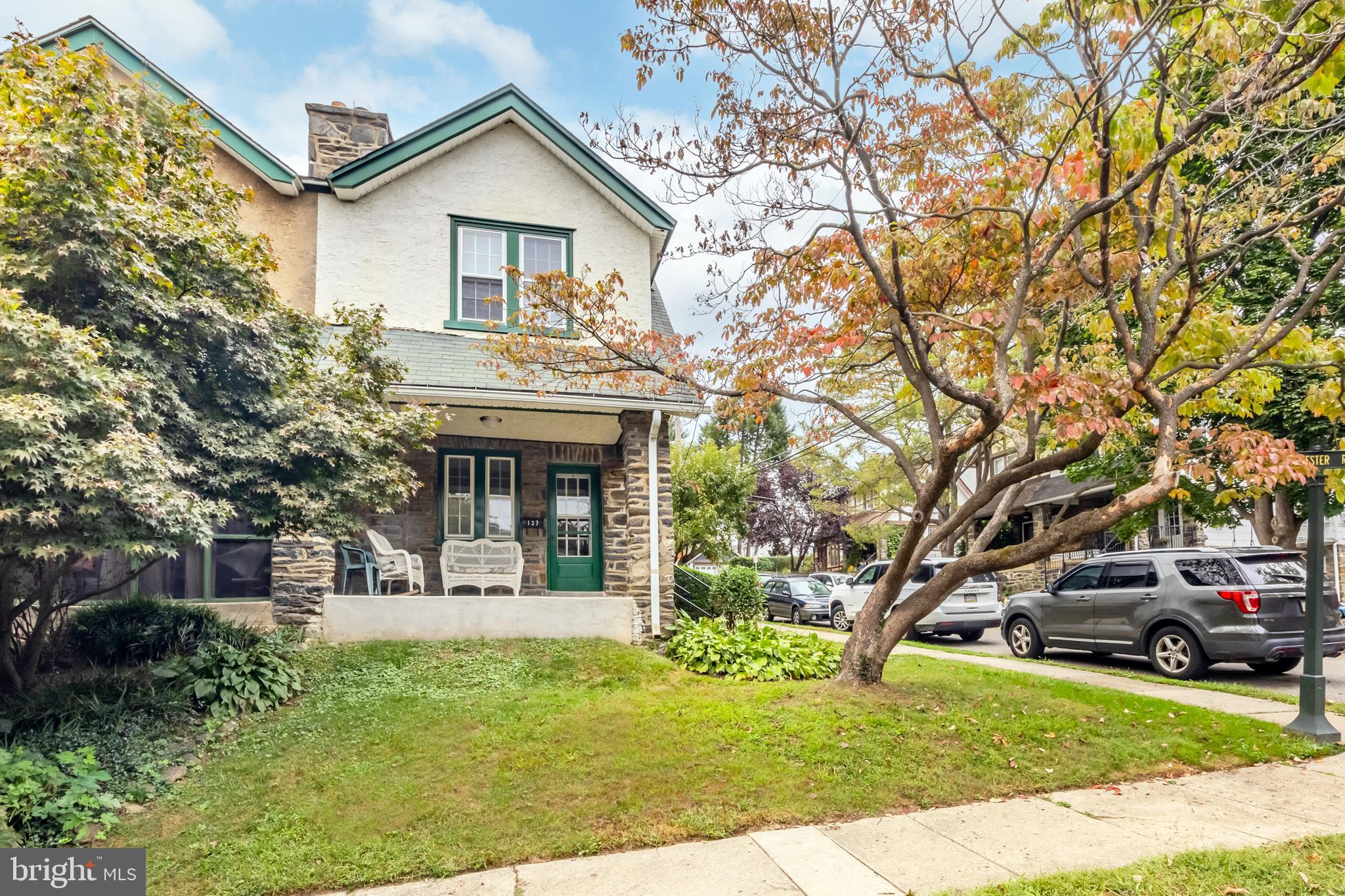 a view of house with yard and car parked