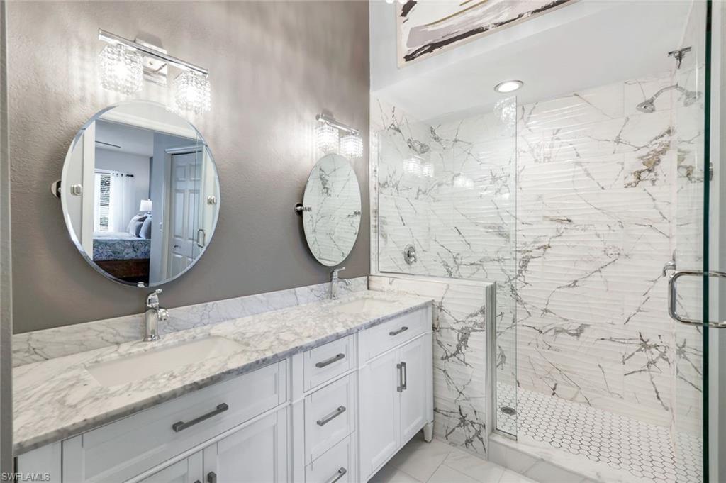 a bathroom with double vanity sink and two mirror