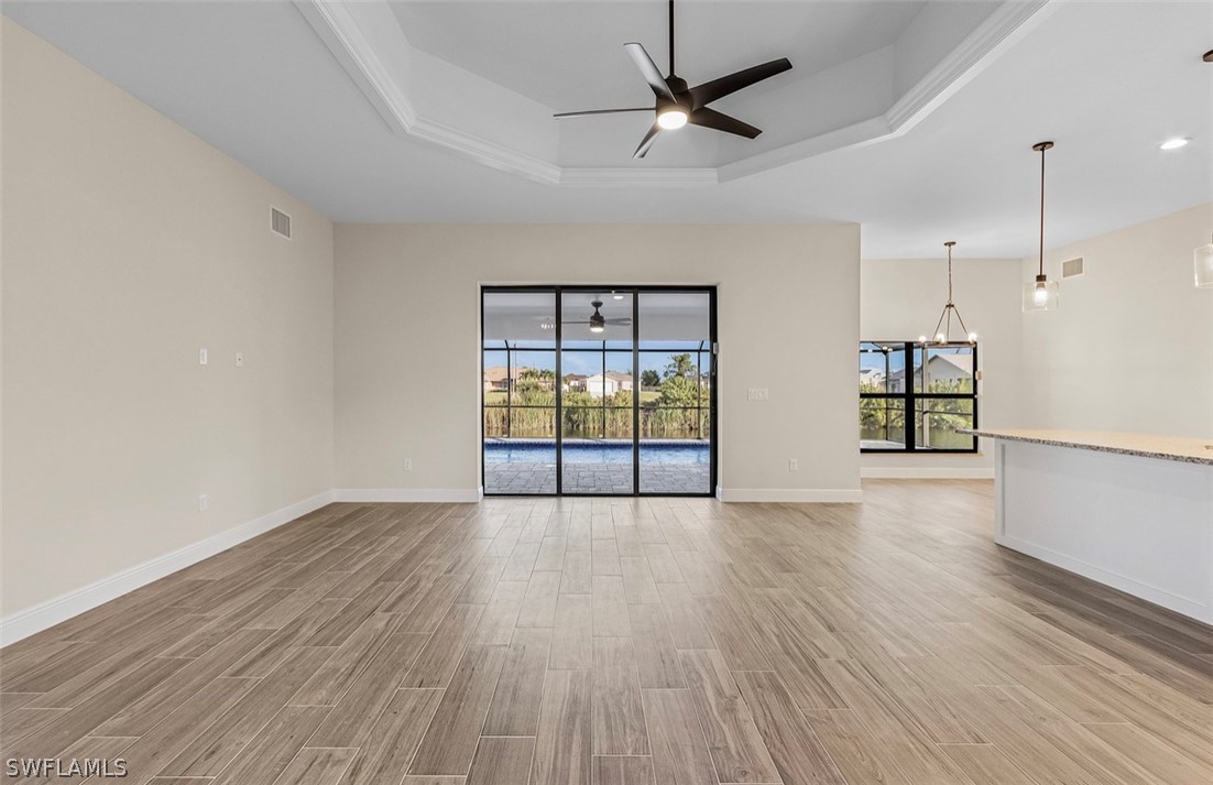 a view of an empty room with window and wooden floor