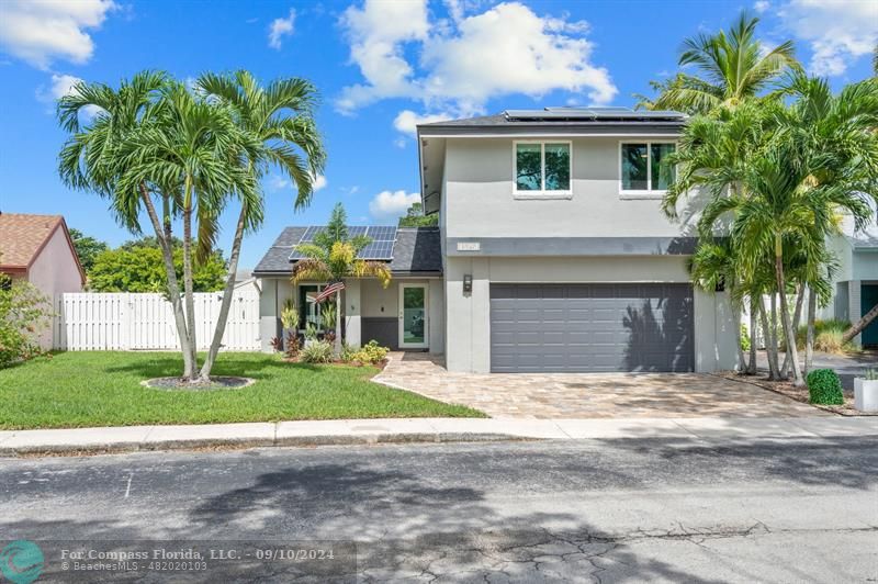 a view of a house with a yard and palm trees