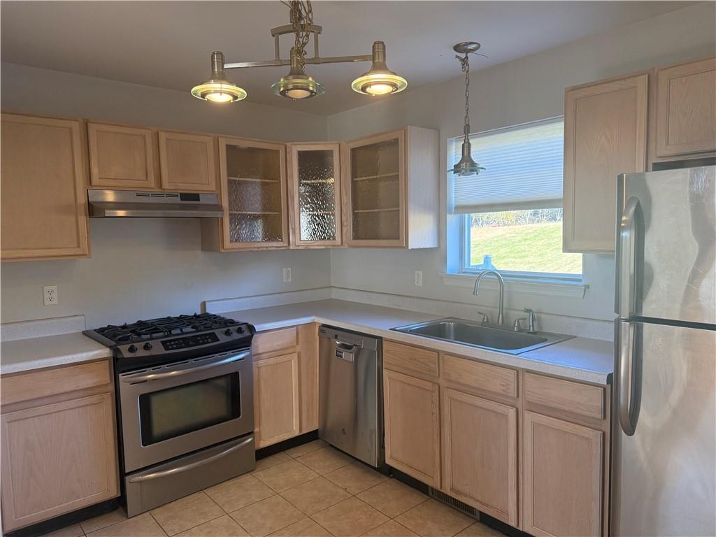 a kitchen with cabinets appliances a sink and a window