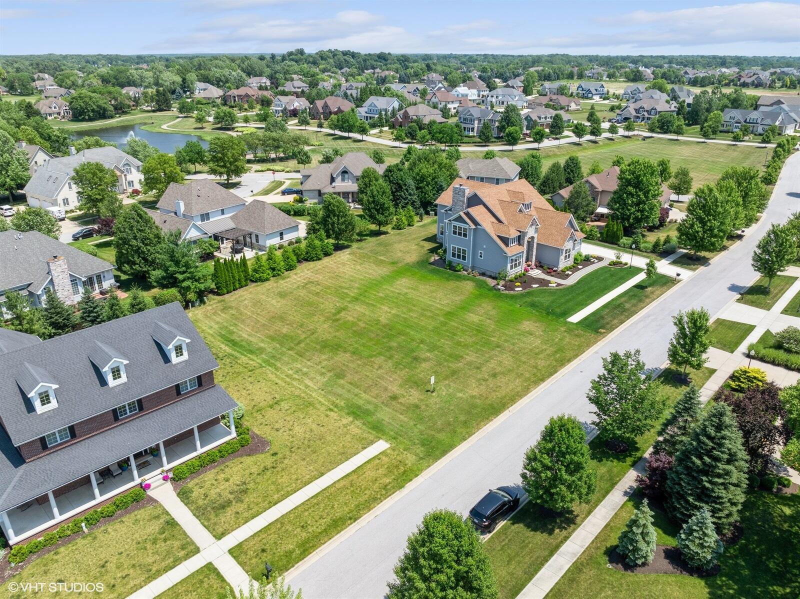 an aerial view of residential houses with outdoor space and trees