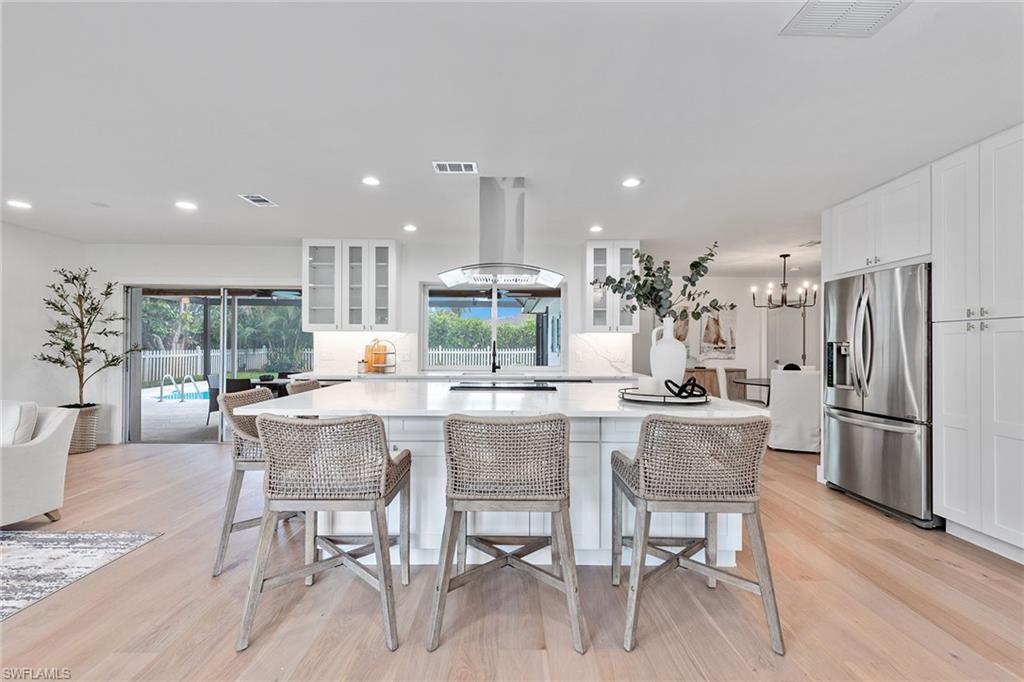 a kitchen with a dining table chairs refrigerator and cabinets