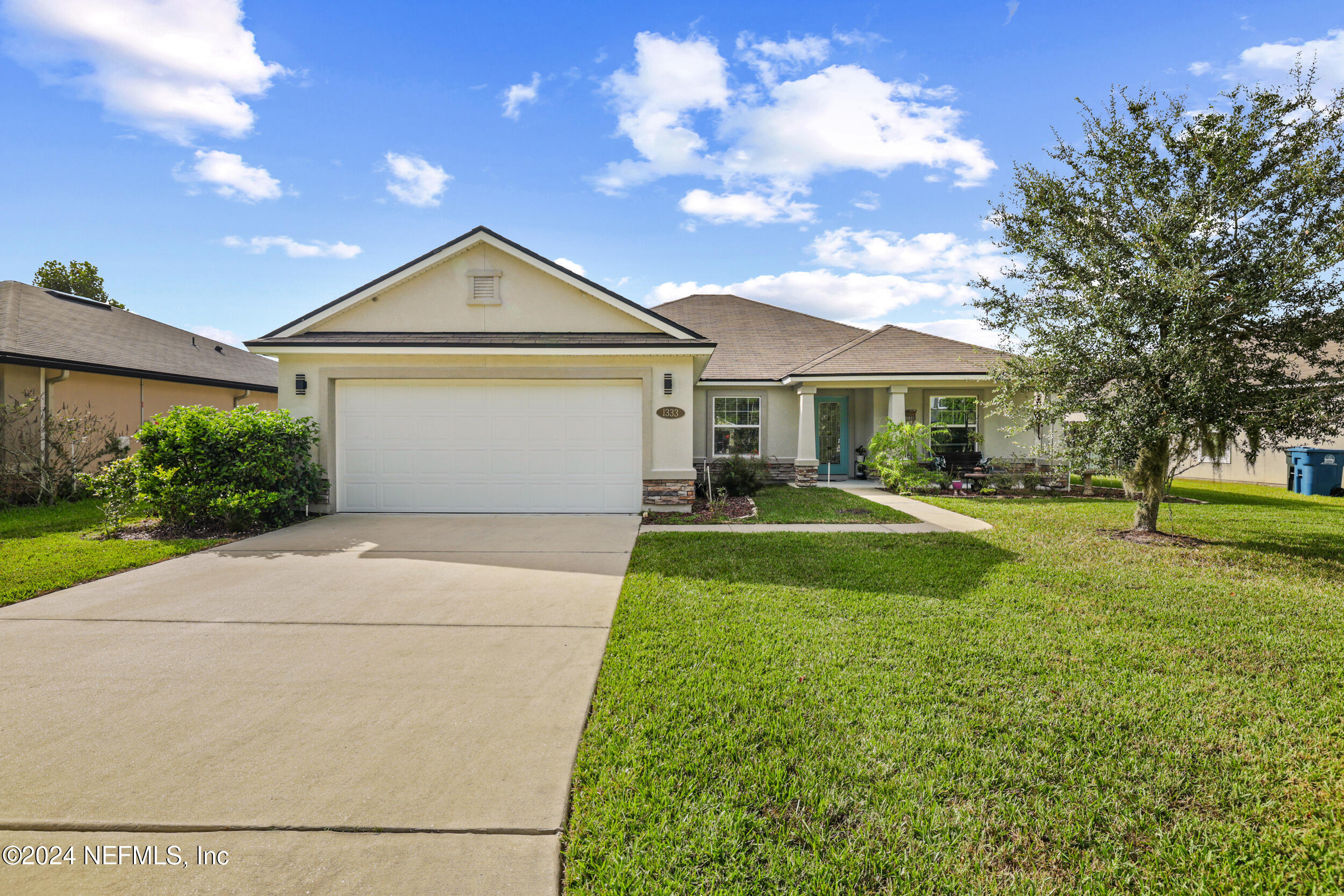 a front view of a house with a yard and trees