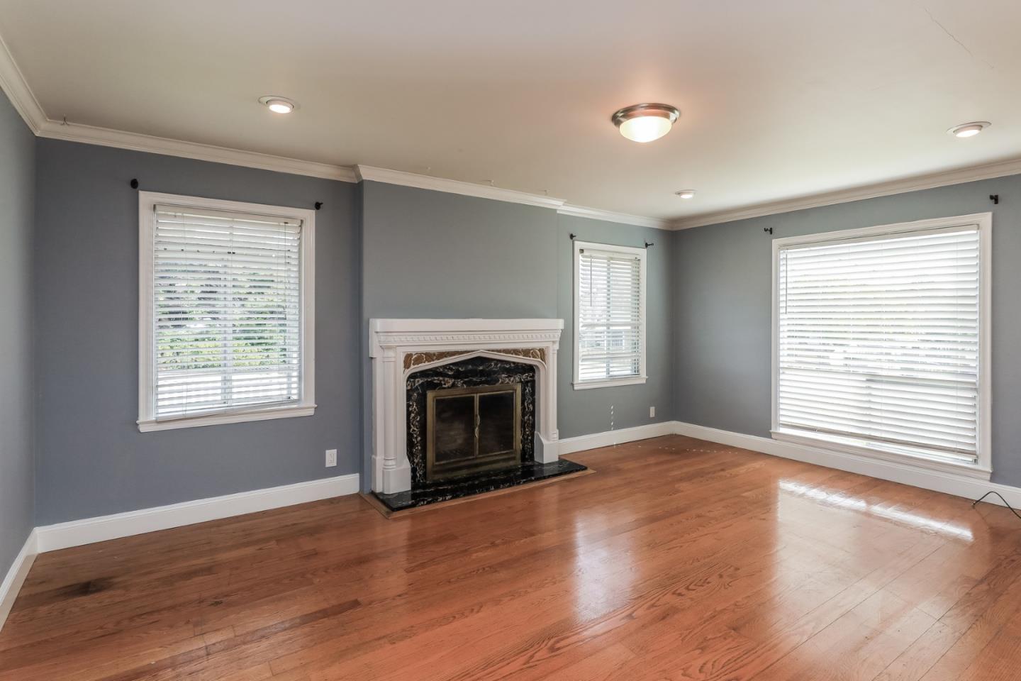 a view of empty room with a fireplace and wooden floor