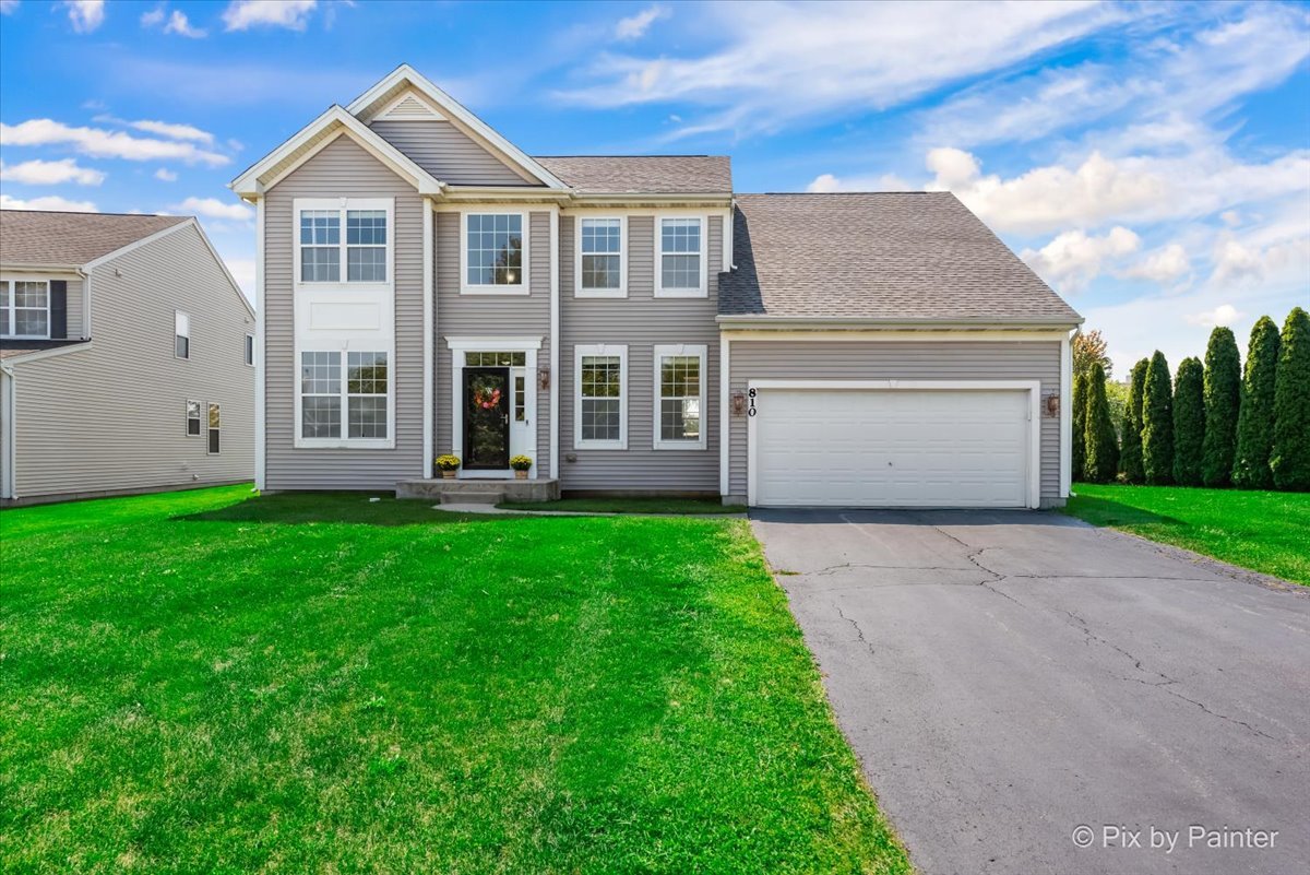 a front view of a house with a yard and garage