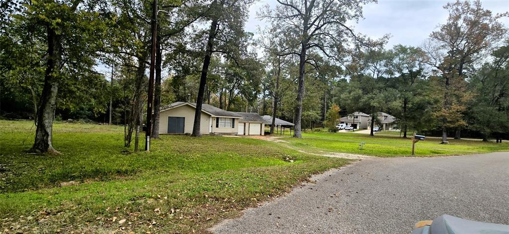 a view of a house with a big yard and large trees