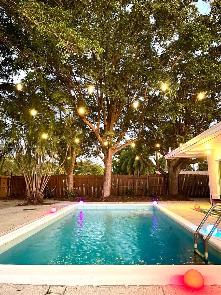 a view of yard with swimming pool and trees