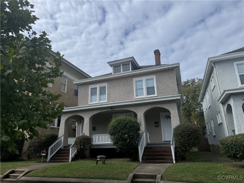 View of front of house with a front lawn and cover