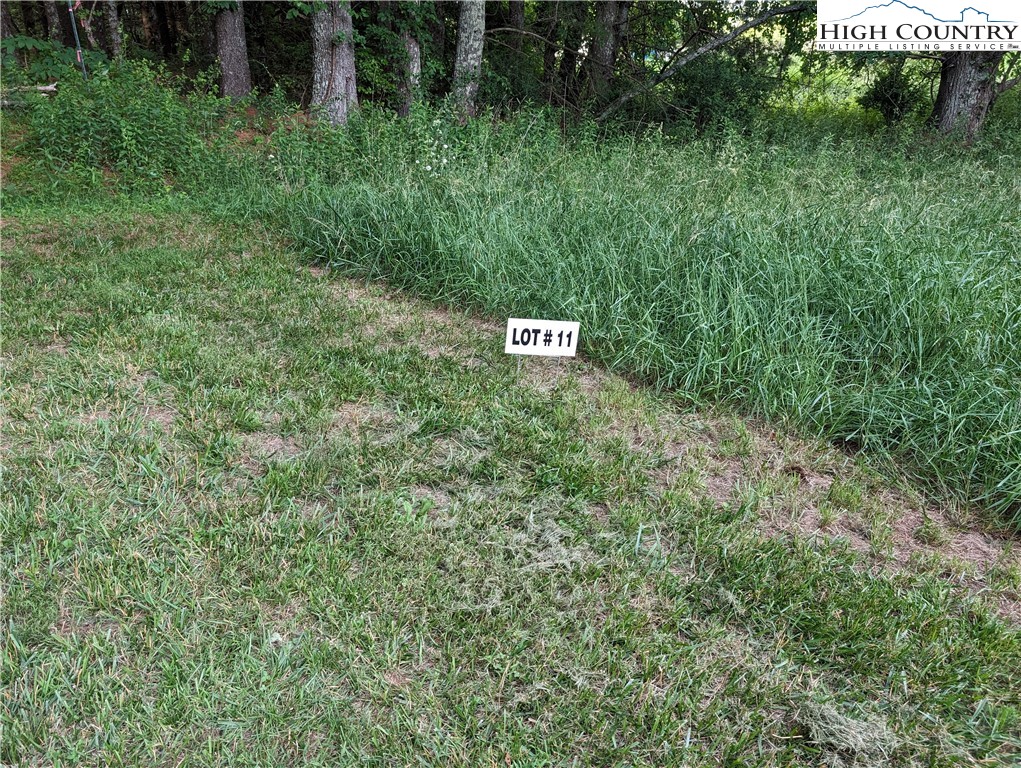 a sign that is sitting in the grass next to a road