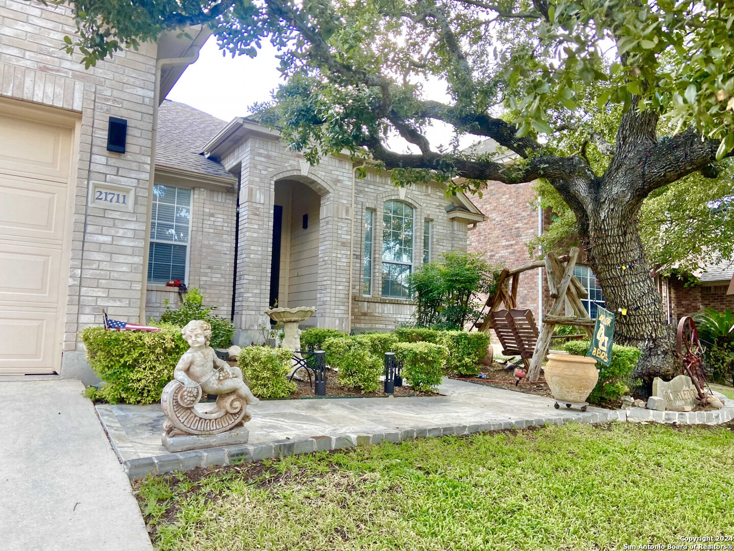 a front view of a house with a yard and potted plants