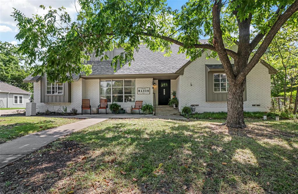 a front view of a house with a yard and trees