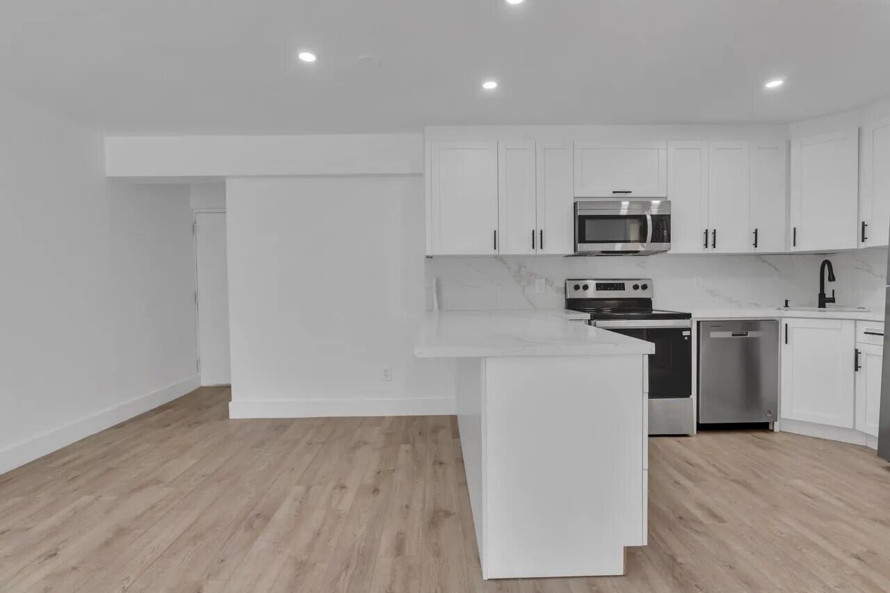 a kitchen with kitchen island a sink and a stove top oven