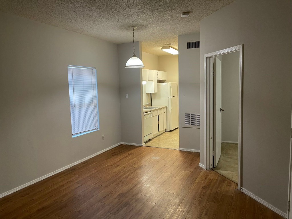 an empty room with wooden floor and a bathroom