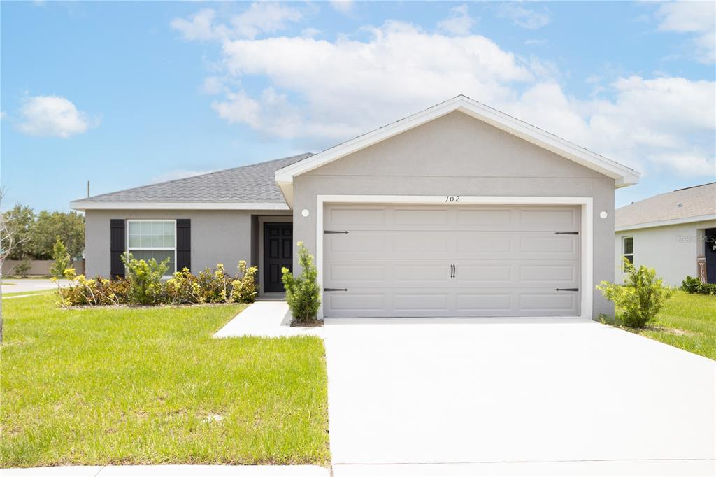 a front view of house with yard and green space