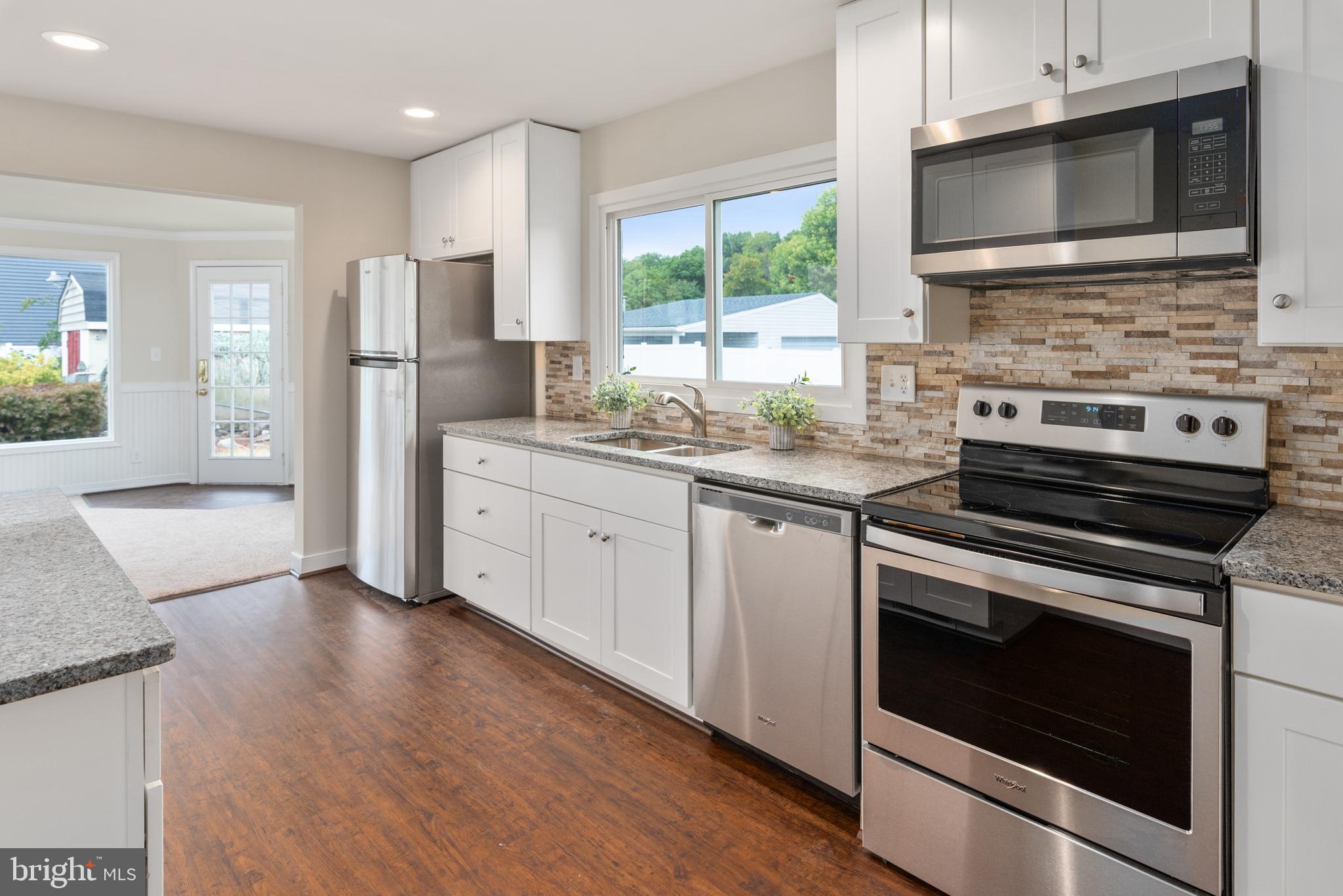 a kitchen with stainless steel appliances a stove microwave and refrigerator