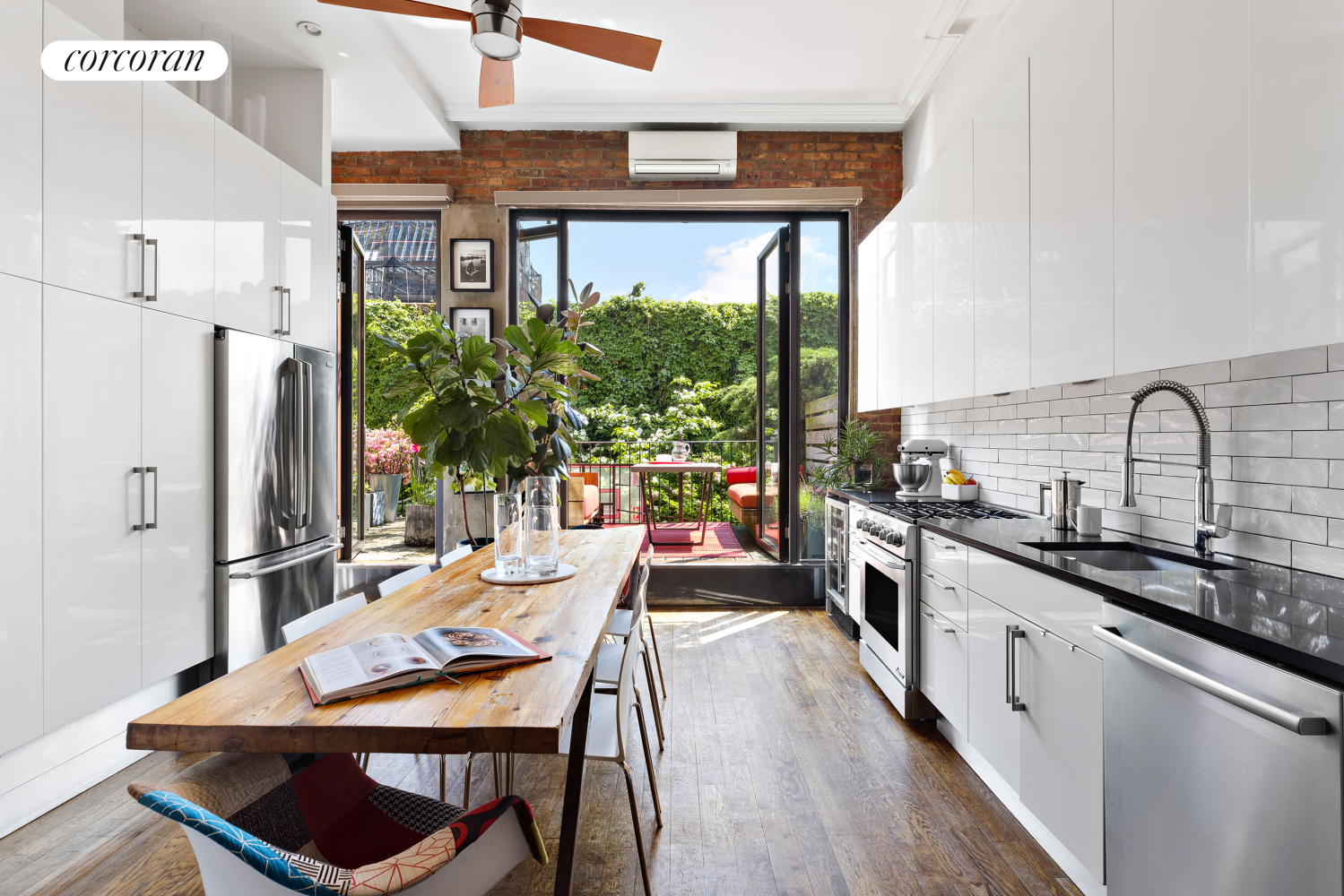 a kitchen with stainless steel appliances a dining table chairs a sink and a refrigerator