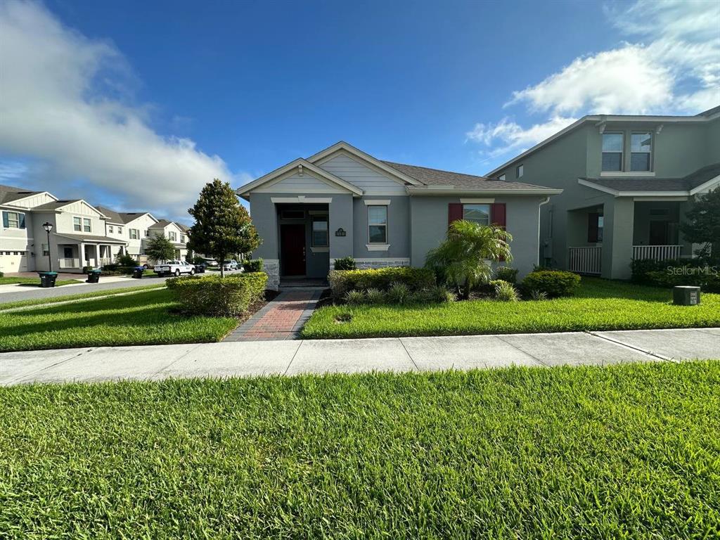 a front view of a house with a yard and potted plants