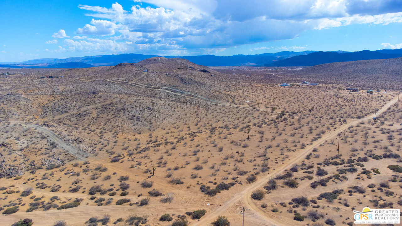 a view of a dry yard with mountains in the background