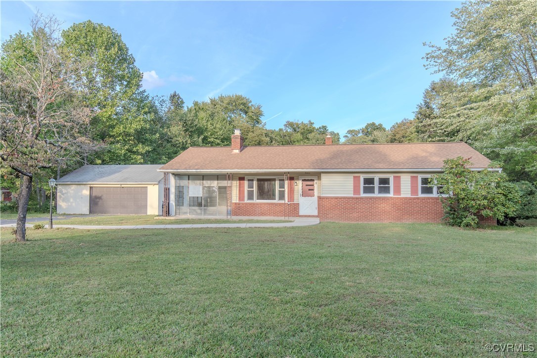 View of front of house with a front yard and a gar