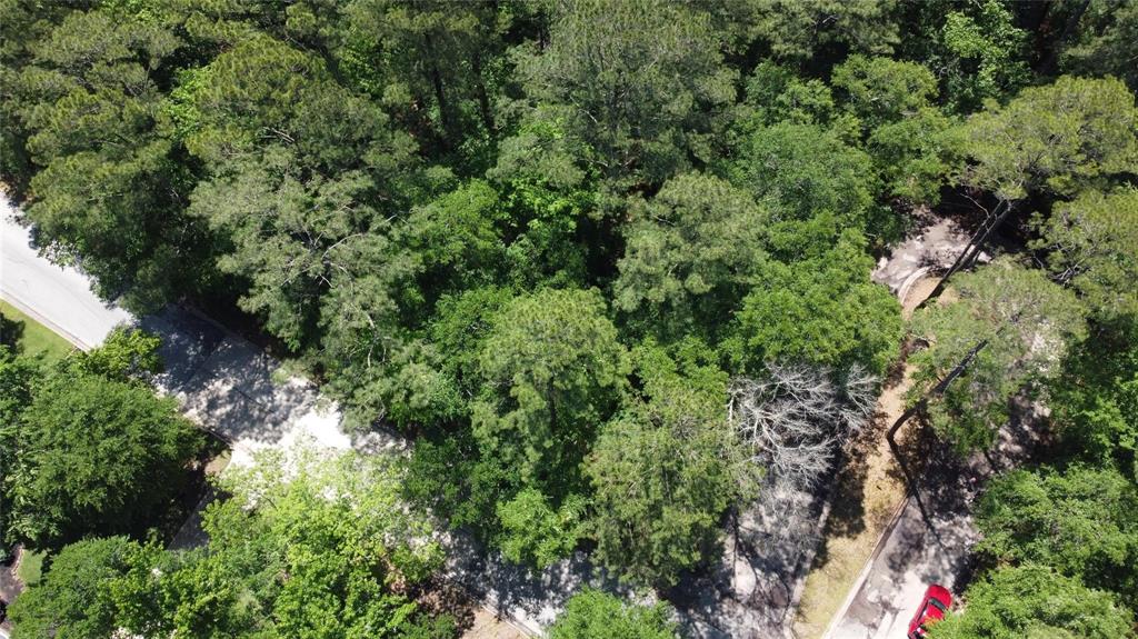 an aerial view of residential house with outdoor space and trees all around