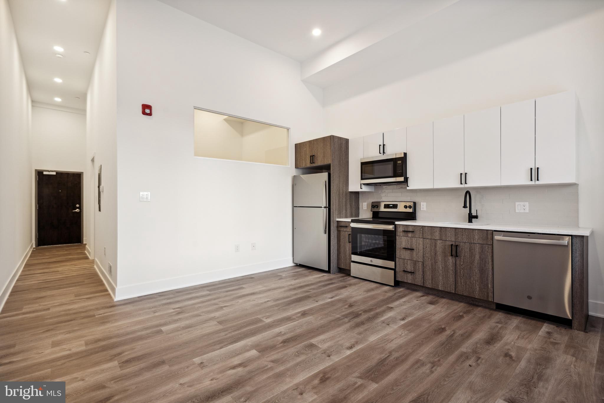 a kitchen with granite countertop a refrigerator and a stove top oven