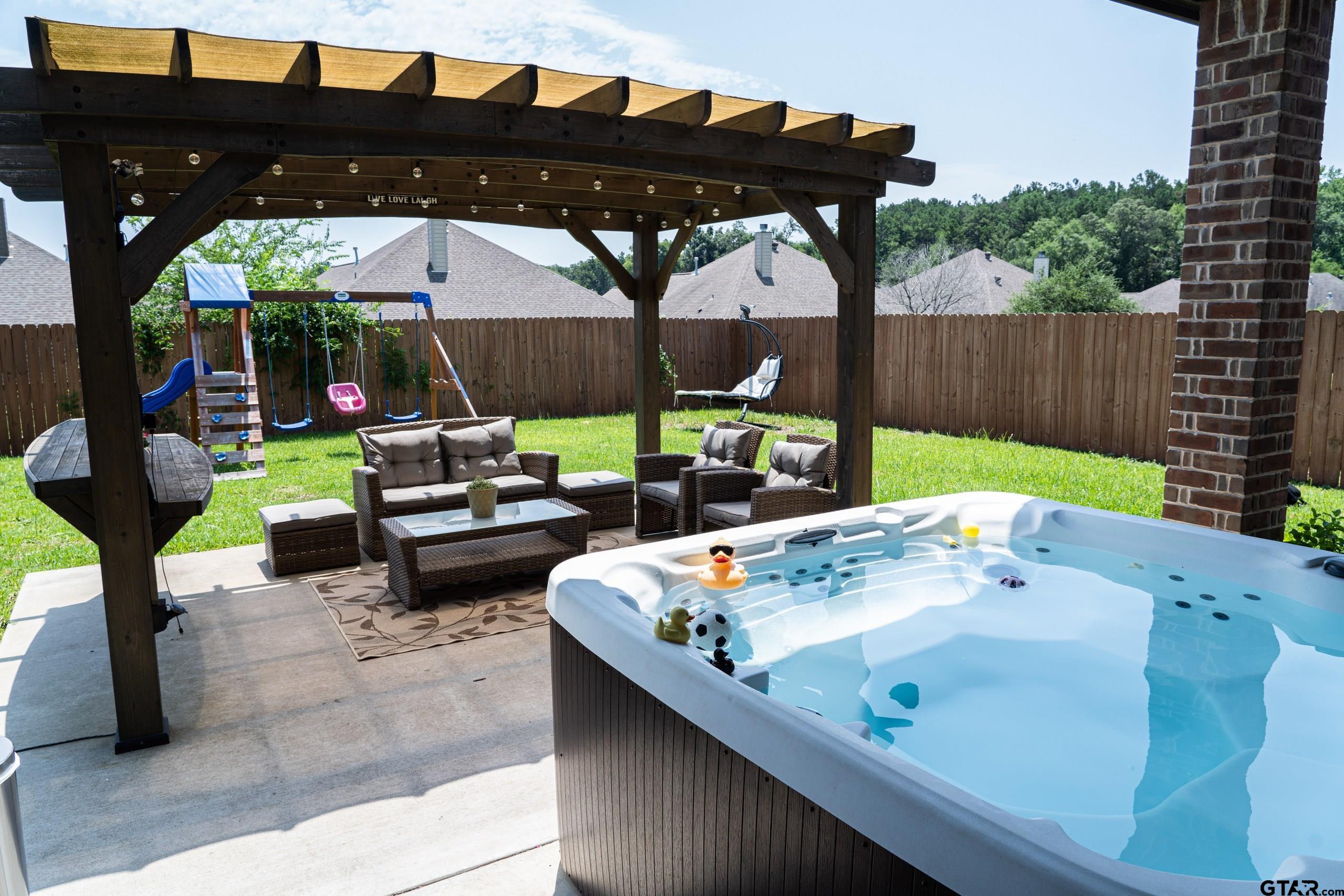 a view of a patio with table and chairs under an umbrella with a small yard