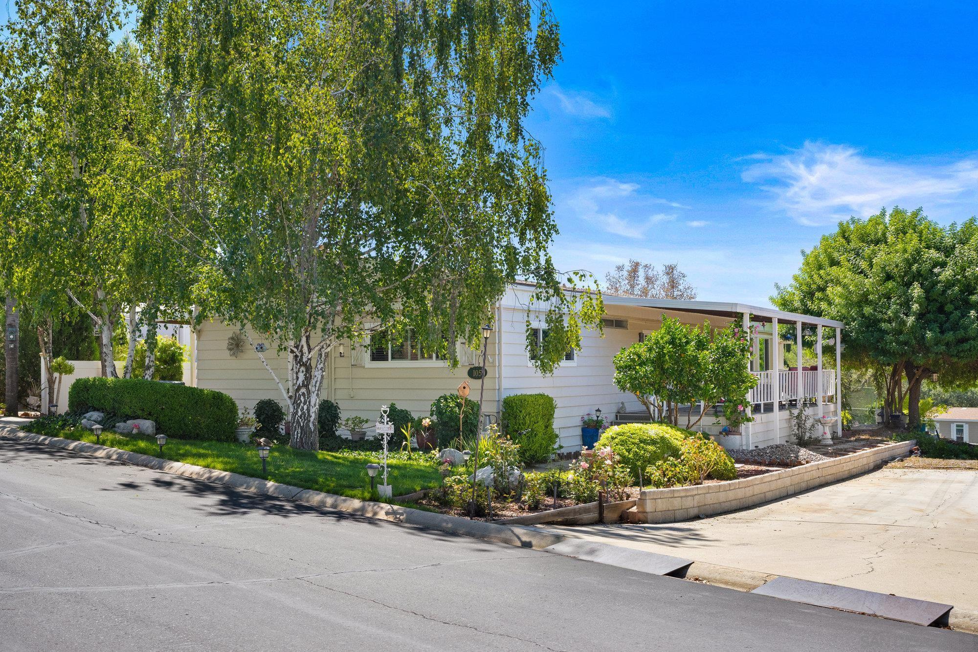 a front view of a house with a yard and potted plants