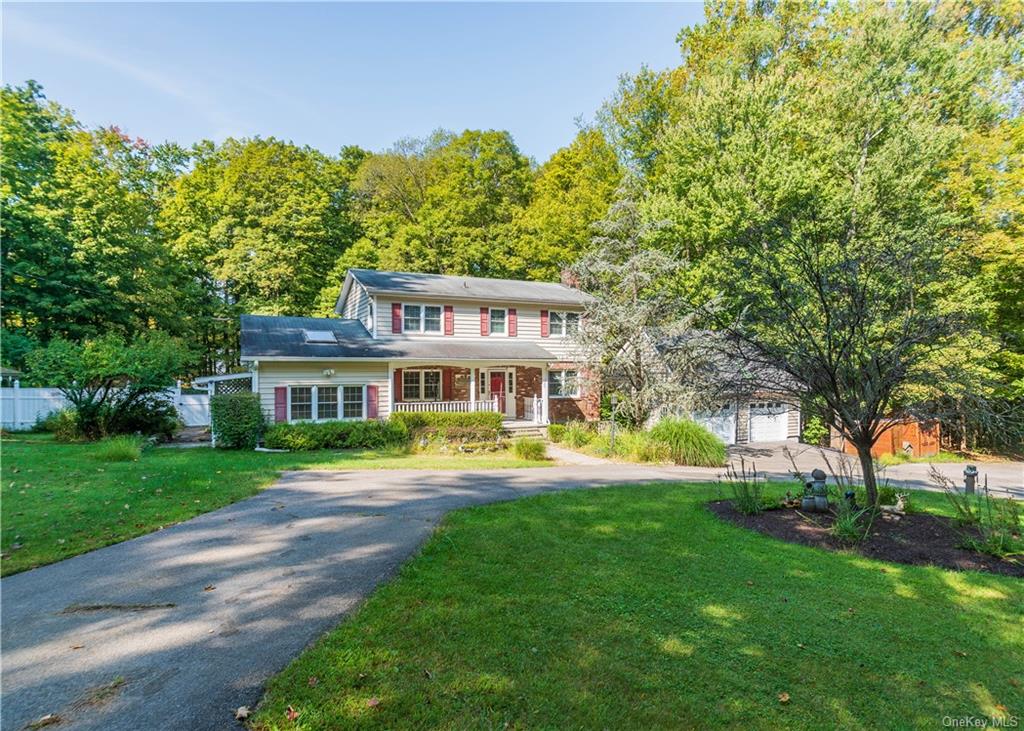 View of front of property featuring a garage, a front yard, and covered porch