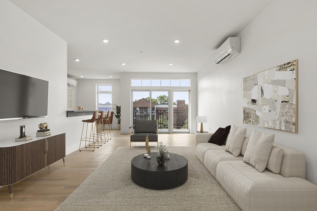 a living room with furniture kitchen view and a large window